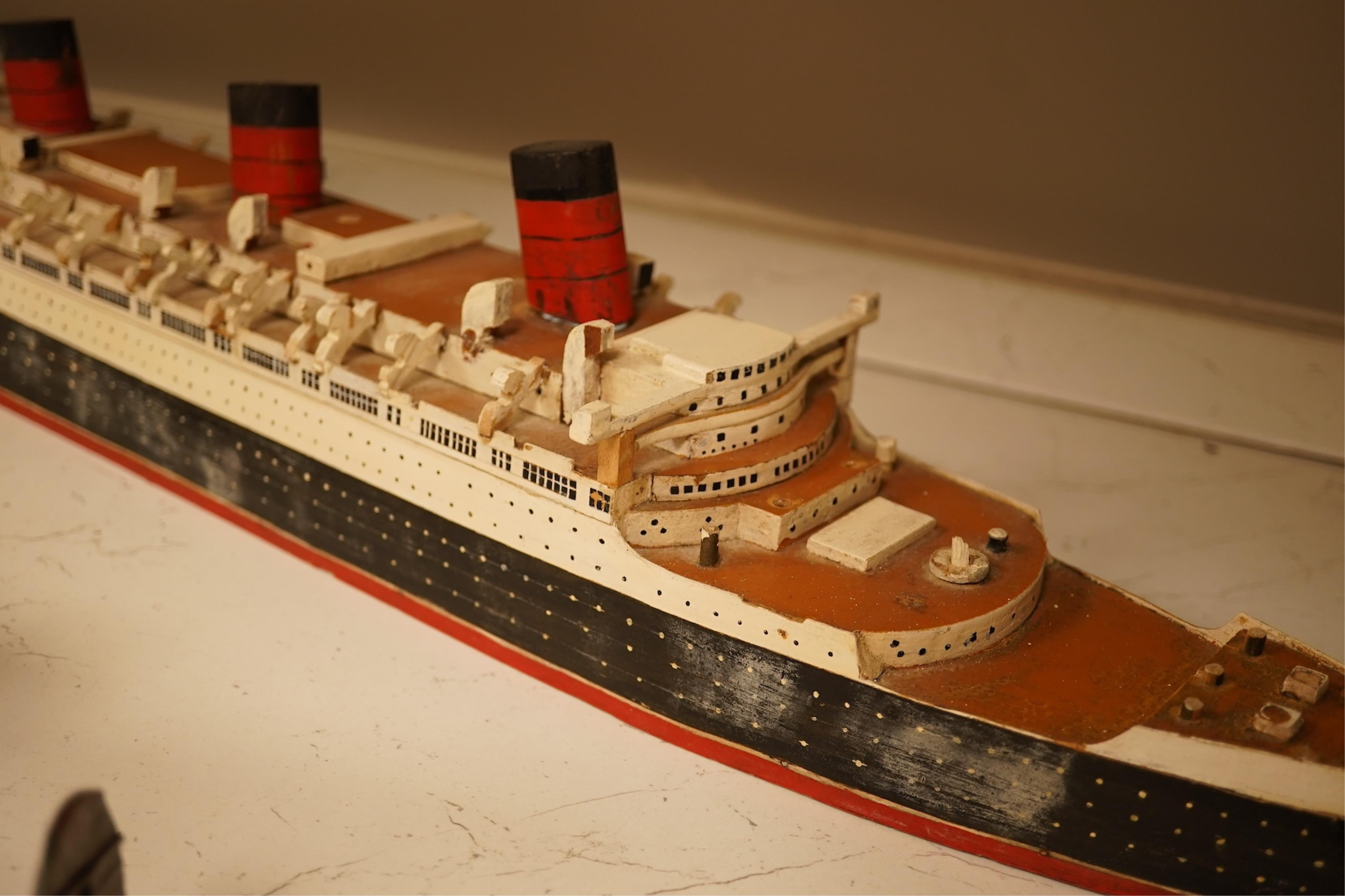 Five decorative metal models of military aircraft, including two Supermarine Spitfires, two First World War, British bi-planes, a German Albatros D.III bi-plane, and a wooden model of RMS Queen Mary, hull 77cm long